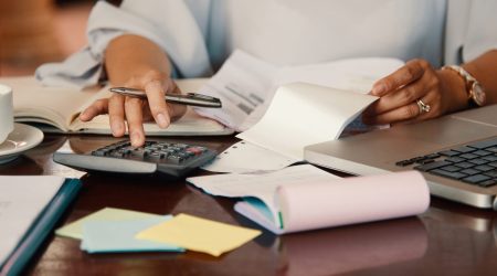 Hands of female entrepreneur working with bills and documents